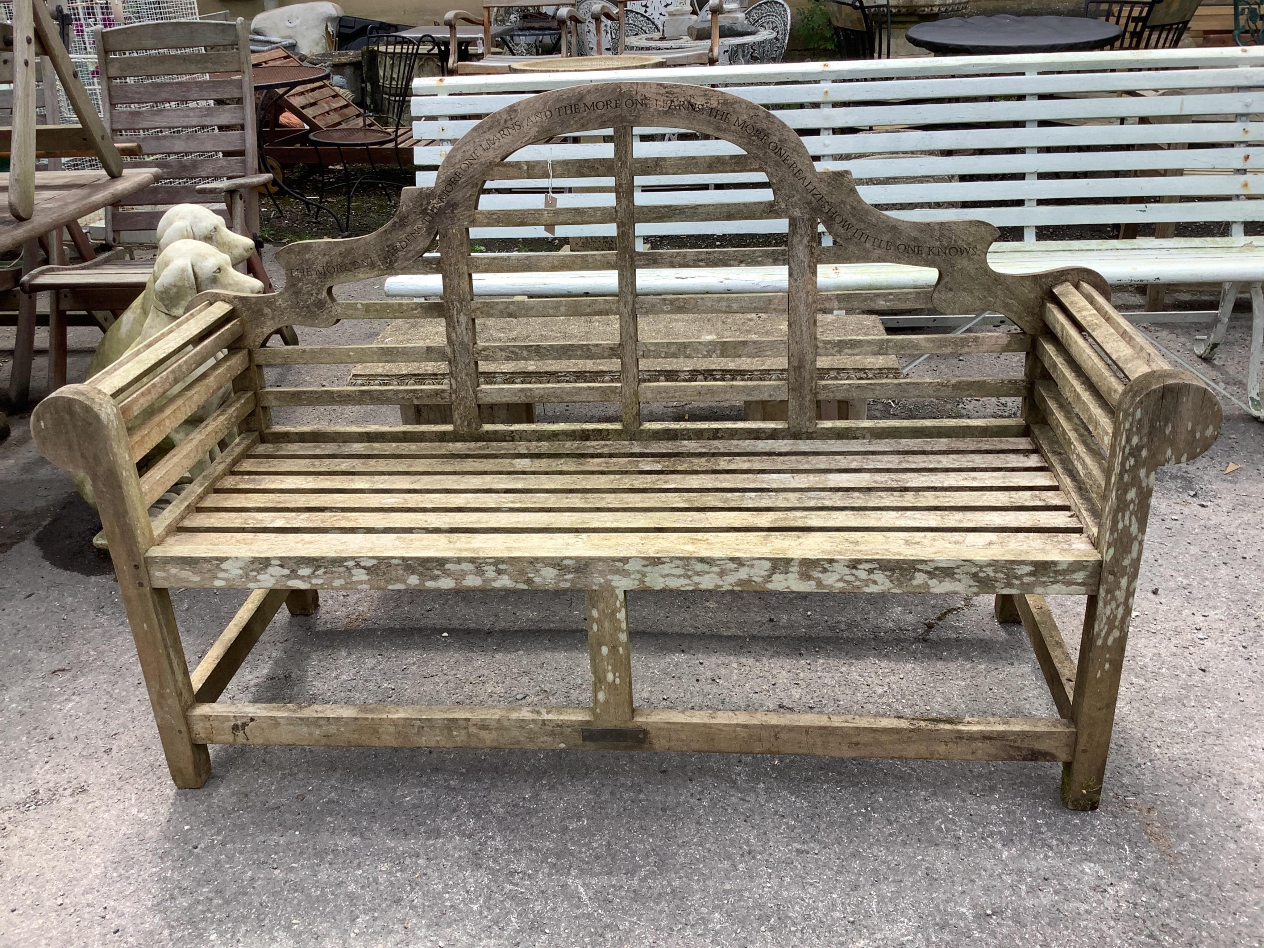 A weathered teak Lutyens style garden bench, with carved inscription, width 55cm, height 106cm